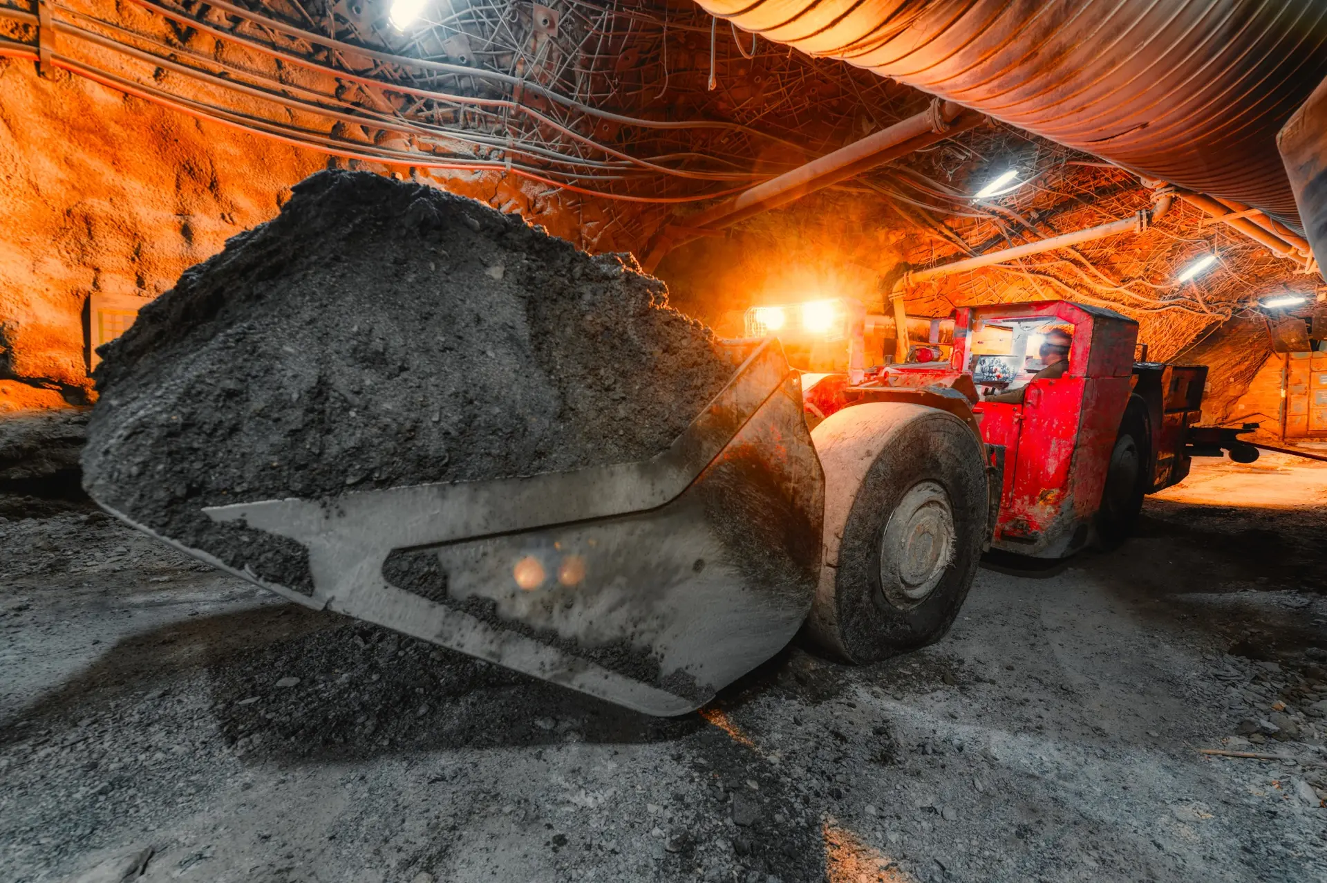 Loader operating beneath temporary ventilation ducting.